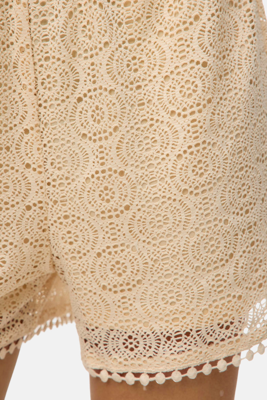 Short beige en dentelle de VERO MODA®, avec bordure à pompons décorative.