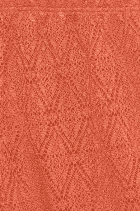 Short orange de VERO MODA, gros plan sur un tissu en dentelle à motif losange texturé.