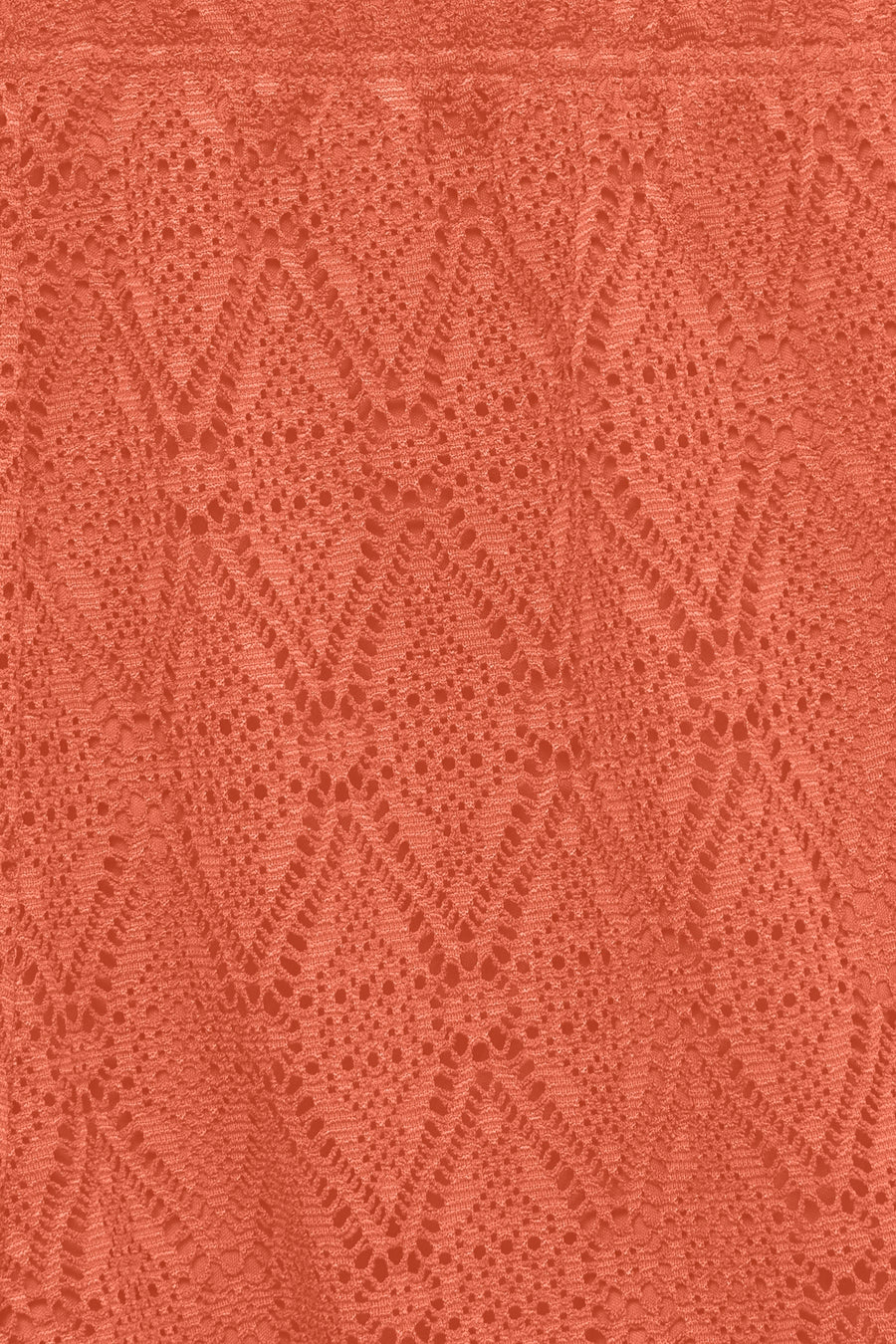 Short orange de VERO MODA, gros plan sur un tissu en dentelle à motif losange texturé.