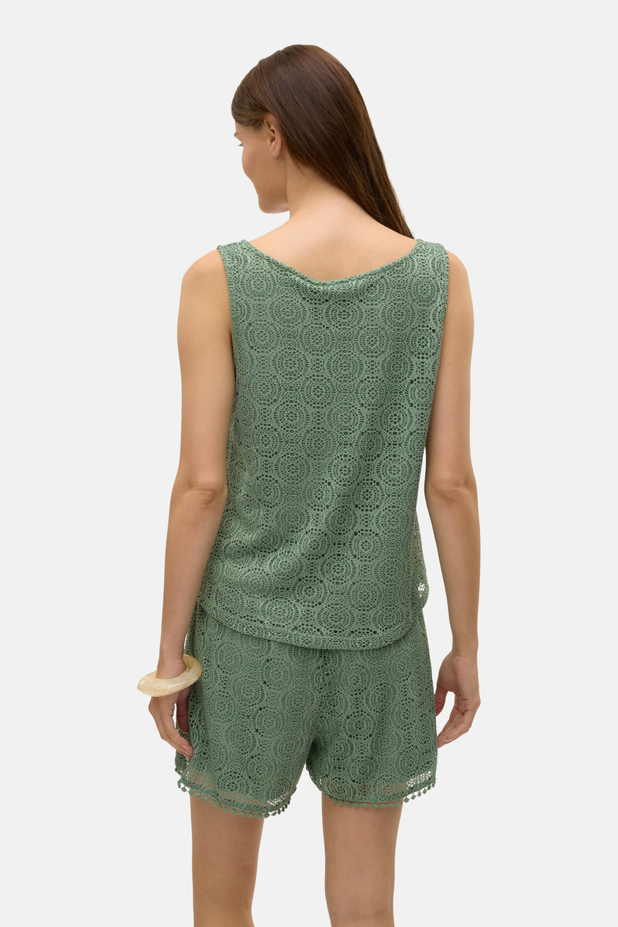 Groen mouwloos topje van VERO MODA®, ajourpatroon, gedragen met een lichte armband.