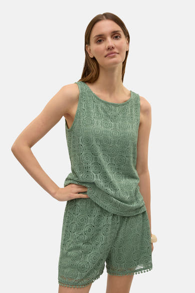 Groen kanten hemdje van VERO MODA, met een open textuur en een gedrapeerde zoom, gedragen met een bijpassende korte broek.