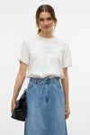 T-shirt à manches courtes blanc de VERO MODA® avec imprimé « Coffee Skater » porté avec une jupe en jean.
