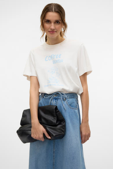 T-shirt blanc à manches courtes de VERO MODA, porté avec une jupe en jean et un sac à main noir.
