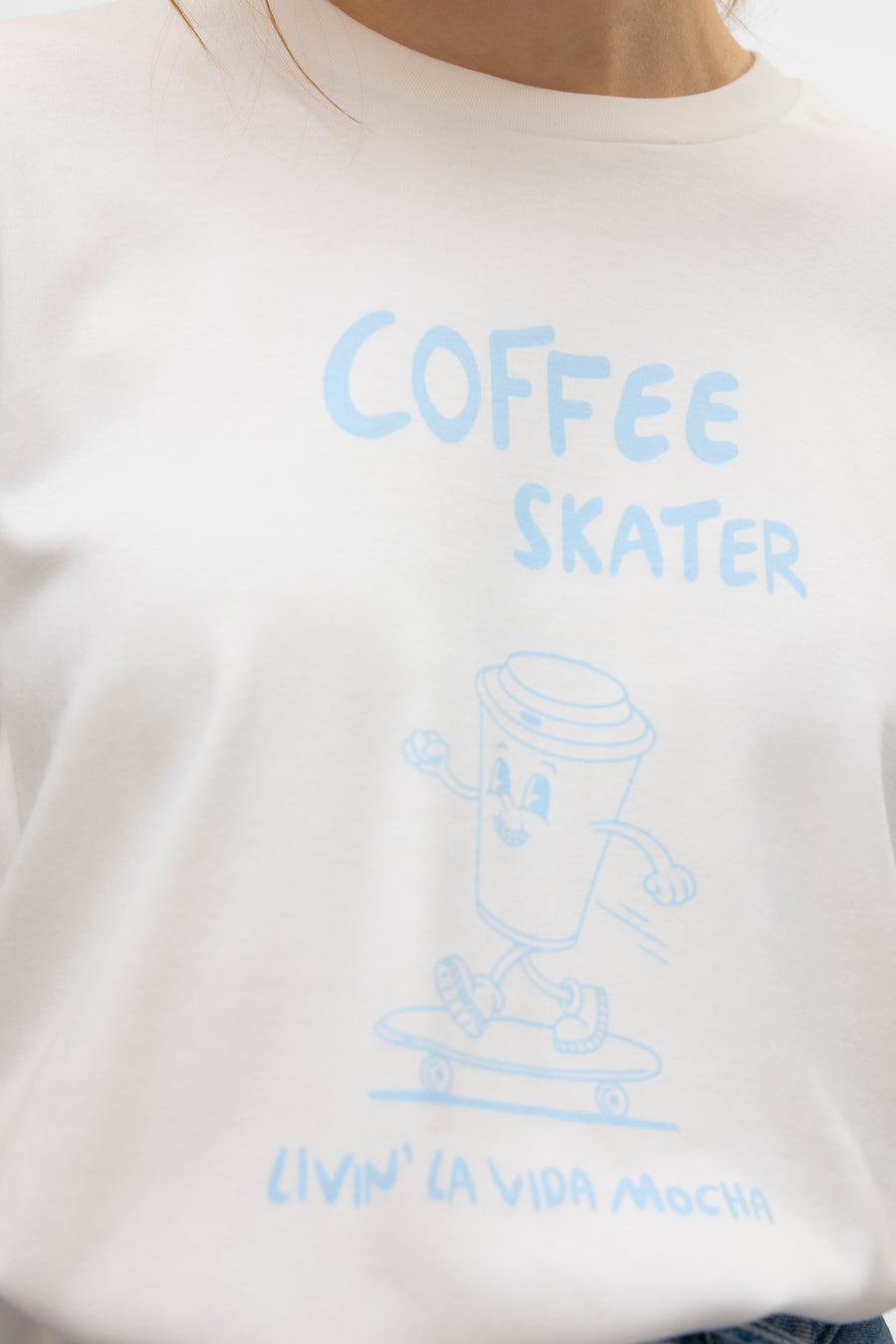 T-shirt à manches courtes blanc de VERO MODA® avec un imprimé humoristique de tasse à café sur un skate.