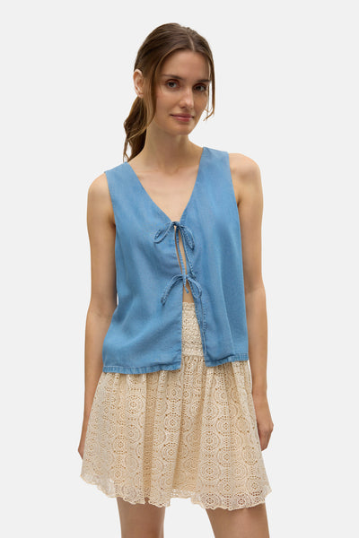 Blouse bleue by VERO MODA, nouée sur le devant, portée avec une jupe en dentelle.