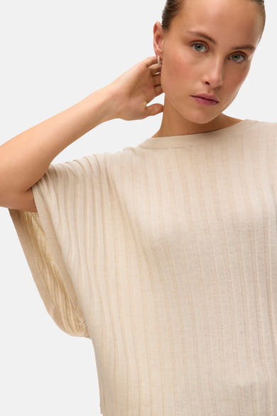 Pull beige en maille côtelée de Vero Moda, avec manches courtes amples et coupe décontractée.