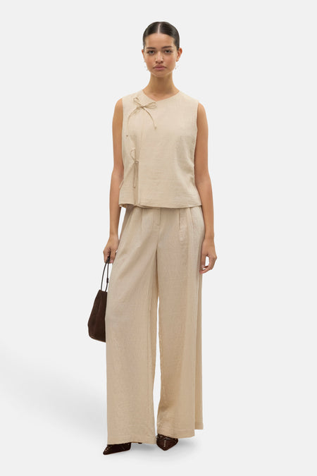 Beige broek van VERO MODA, met een wijde pasvorm en gedragen met een bijpassend topje en een handtas.