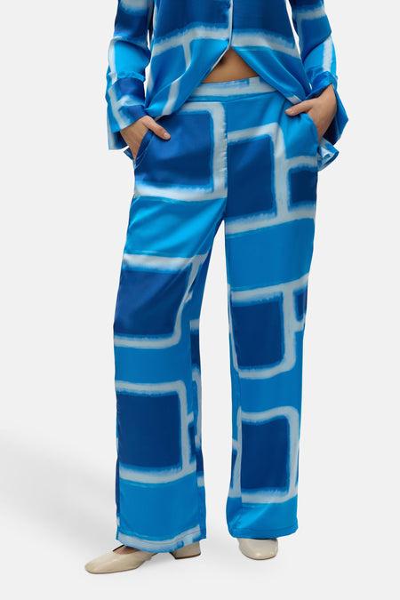 Blauwe broek van VERO MODA® met een abstract grafisch patroon in wit, wijd uitlopend model.