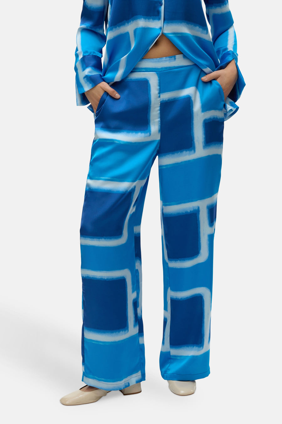 Blauwe broek van VERO MODA® met een abstract grafisch patroon in wit, wijd uitlopend model.