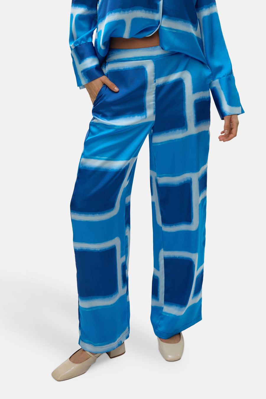 Blauwe broek met blokpatroon van VERO MODA®, met één zak en crèmekleurige schoenen.