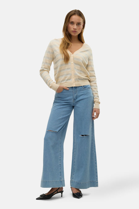 Beige gestreept vest van VERO MODA®, gedragen met een wijde gescheurde jeans en zwarte pumps.