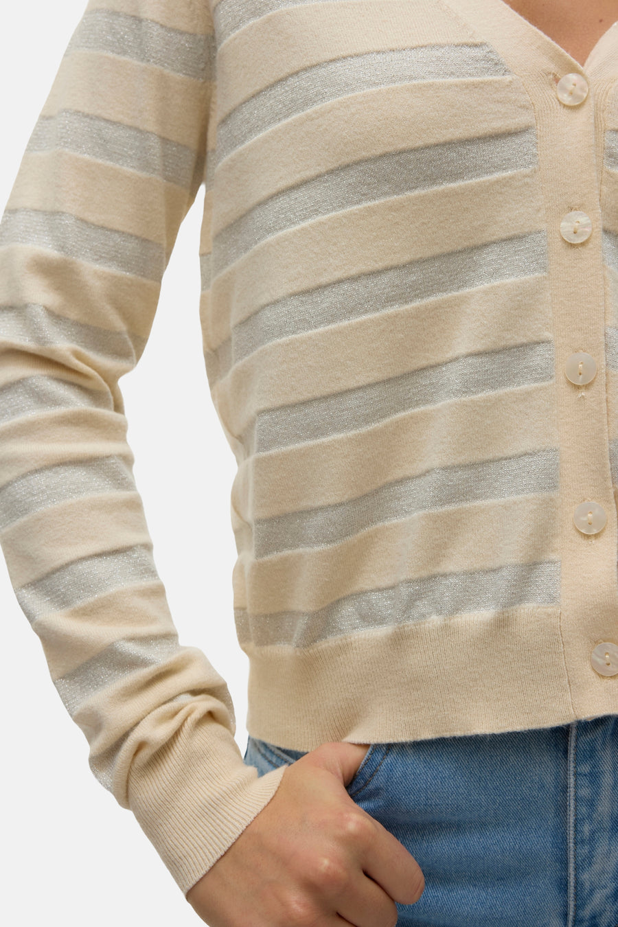Cardigan beige rayé de VERO MODA, avec des boutons et porté avec un jean.
