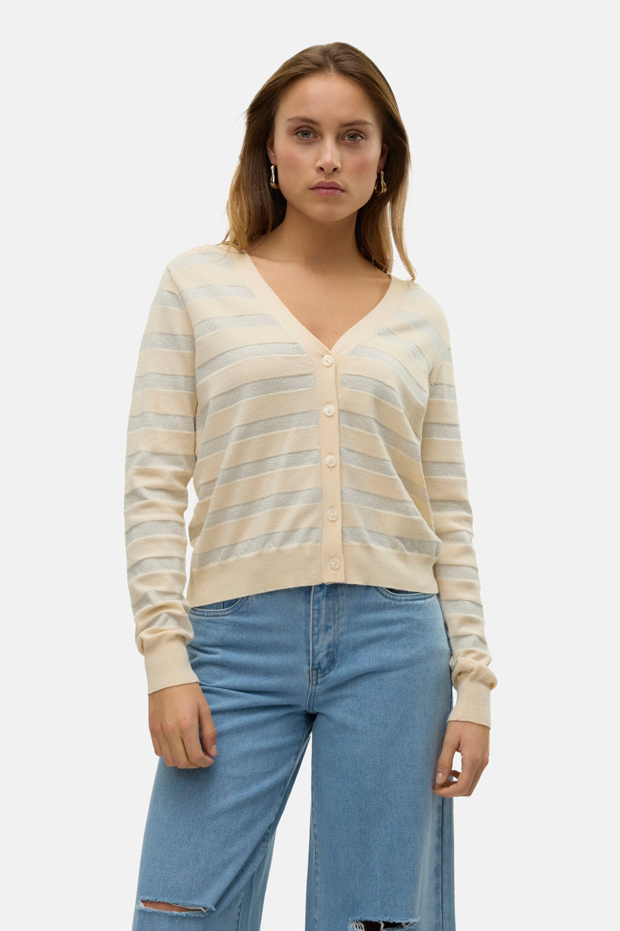 Cardigan beige à rayures brillantes de VERO MODA, porté avec un jean délavé troué.