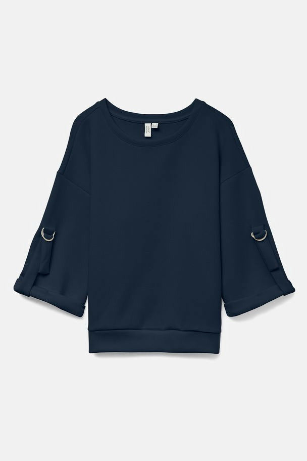 Sweat bleu de VERO MODA avec manches trois-quarts à anneaux décoratifs métalliques.