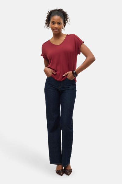 T-shirt rouge à manches courtes de Vero Moda, porté avec un jean et un bracelet en bois.