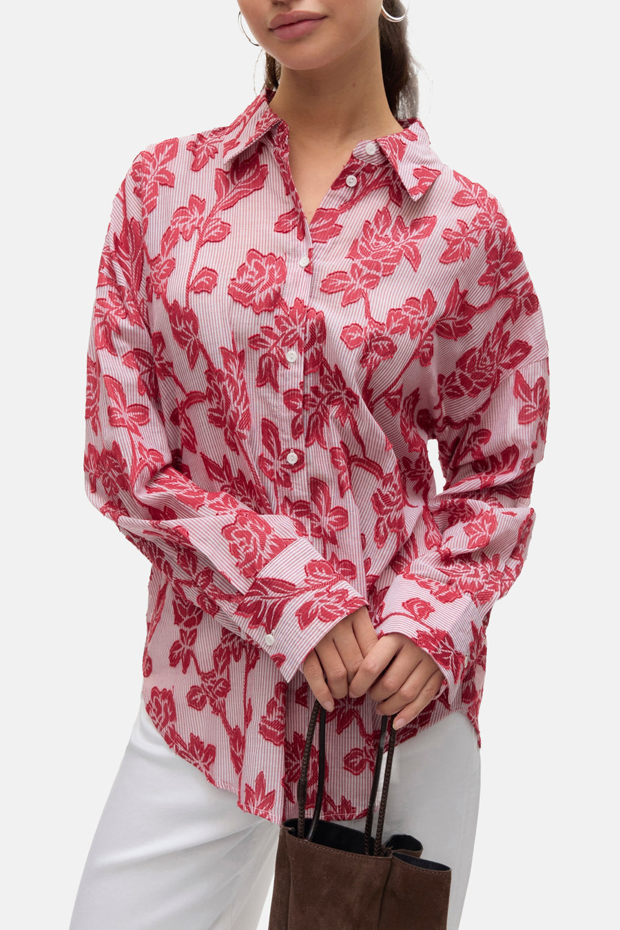 Rood gestreept en bloemig overhemd met lange mouwen van VERO MODA, gedragen met een witte broek en een bruine tas.