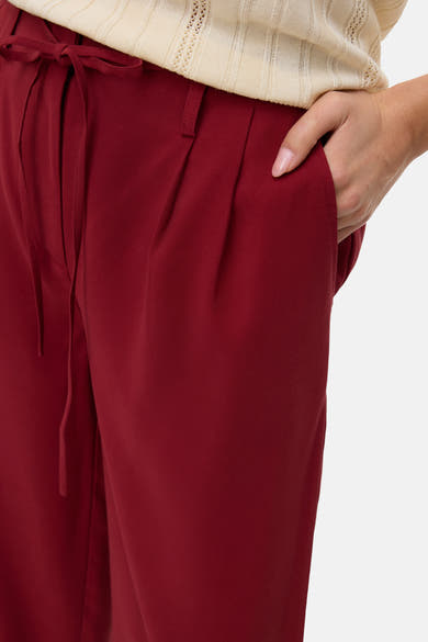 Rode broek van Vero Moda met strikceintuur en geplooide details.