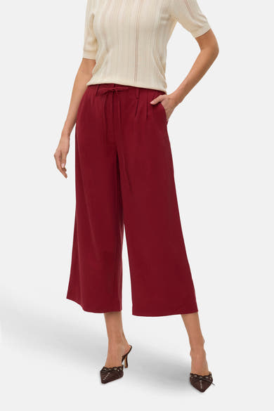 Losse rode broek van Vero Moda, met een taille met trekkoord en een fijngebreid topje erbij gedragen.