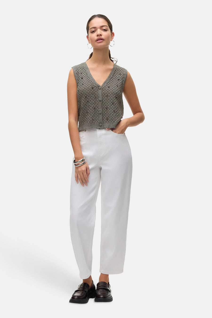 Jean blanc en denim de VERO MODA, porté avec un gilet boutonné gris et des mocassins marron.