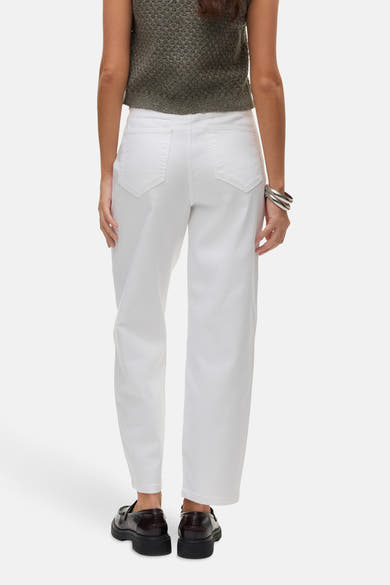 Jean blanc en denim de VERO MODA, présenté de dos, avec un pull vert et des bracelets argentés.