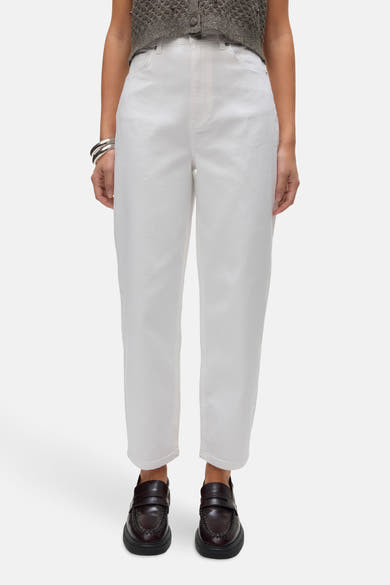 Jean en denim blanc de Vero Moda, porté avec des mocassins bordeaux et des bracelets argentés.