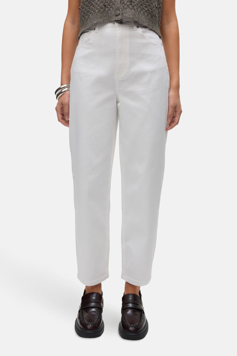 Jean en denim blanc de Vero Moda, porté avec des mocassins bordeaux et des bracelets argentés.