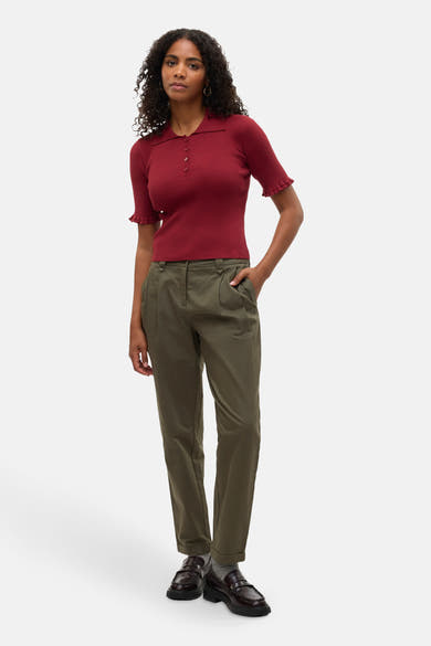 Polo bordeaux à manches courtes de VERO MODA®, porté avec un pantalon vert olive.