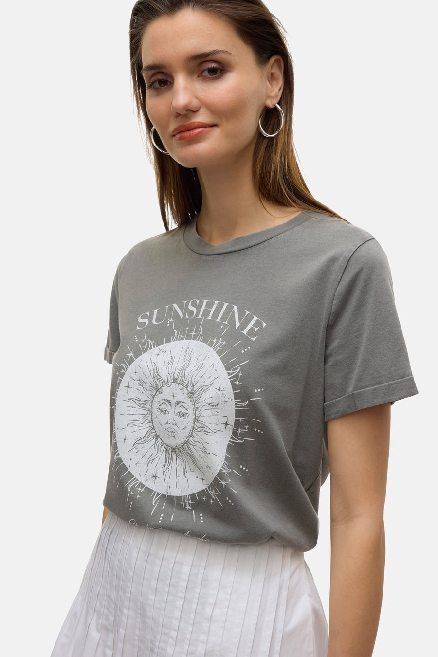 Jupe longue blanche plissée de VERO MODA, portée avec un t-shirt gris à motif soleil.