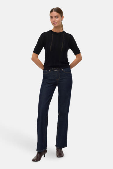 Pull à col rond noir de VERO MODA porté avec un jean taille haute et des bottines.