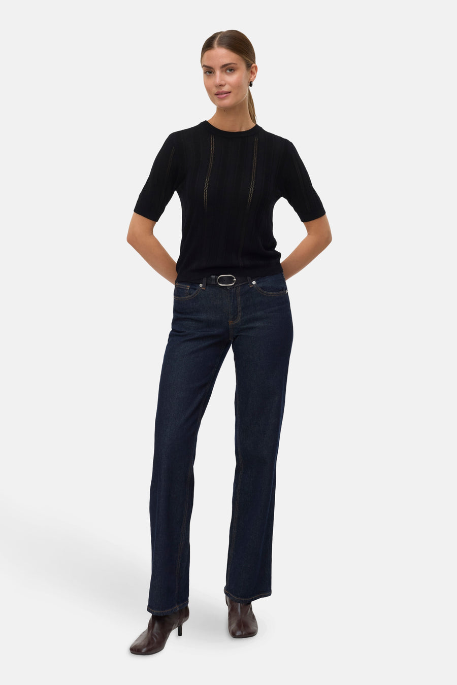 Pull à col rond noir de VERO MODA porté avec un jean taille haute et des bottines.