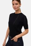 Pull noir à col rond de Vero Moda, avec détails ajourés et porté avec un jean foncé