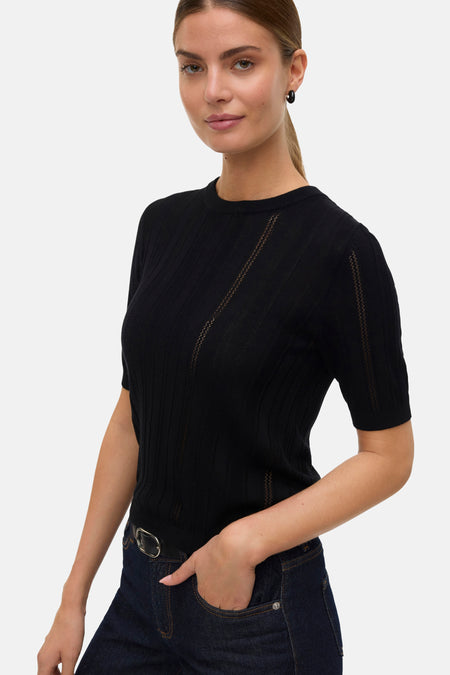 Zwarte trui met ronde hals van Vero Moda, met ajourdetails en gedragen met een donkere jeans