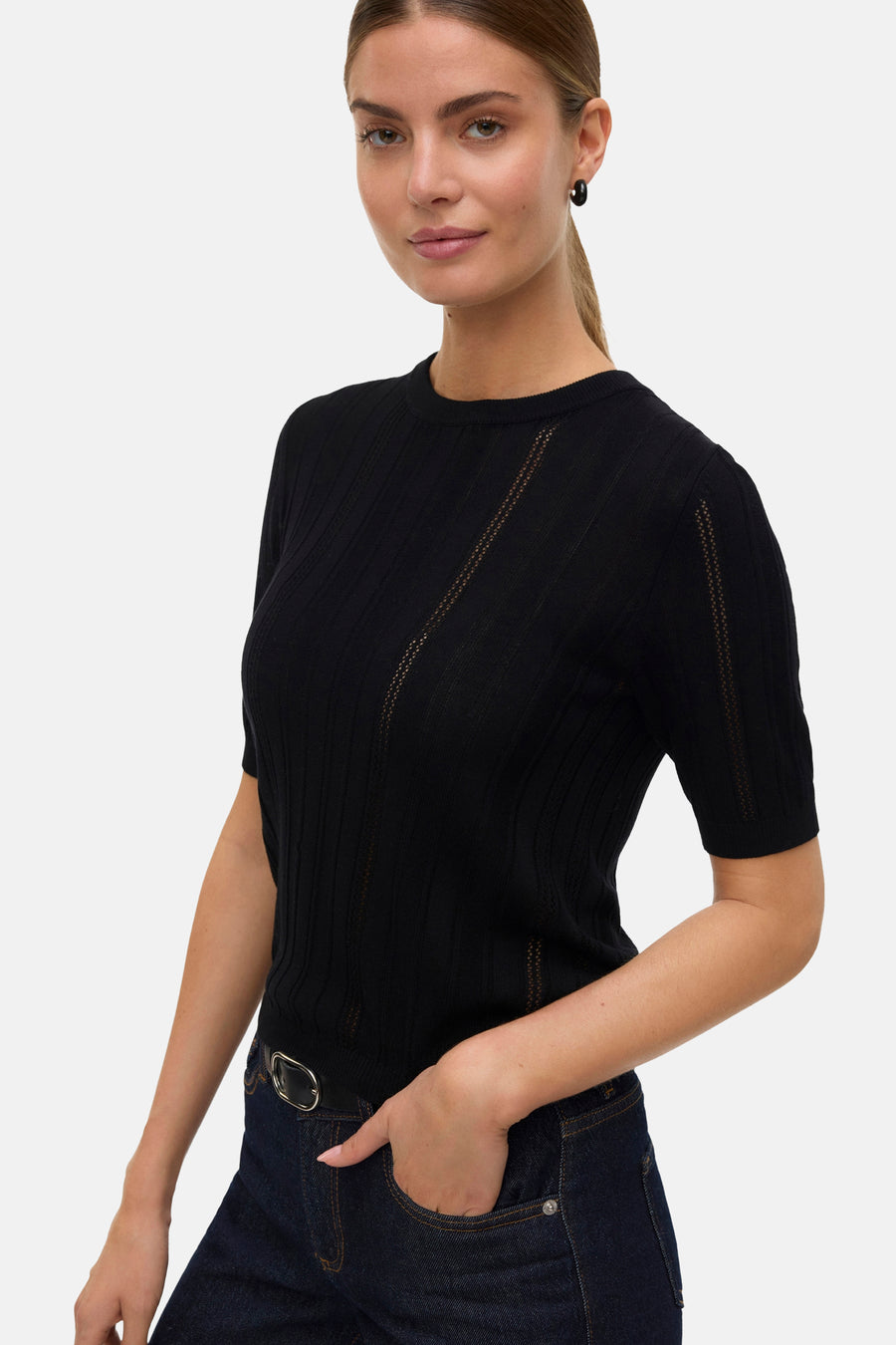 Pull noir à col rond de Vero Moda, avec détails ajourés et porté avec un jean foncé