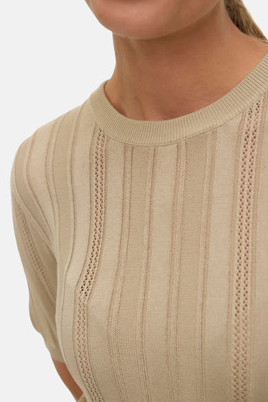 Pull à col rond beige de VERO MODA, avec des motifs ajourés verticaux sur le devant.