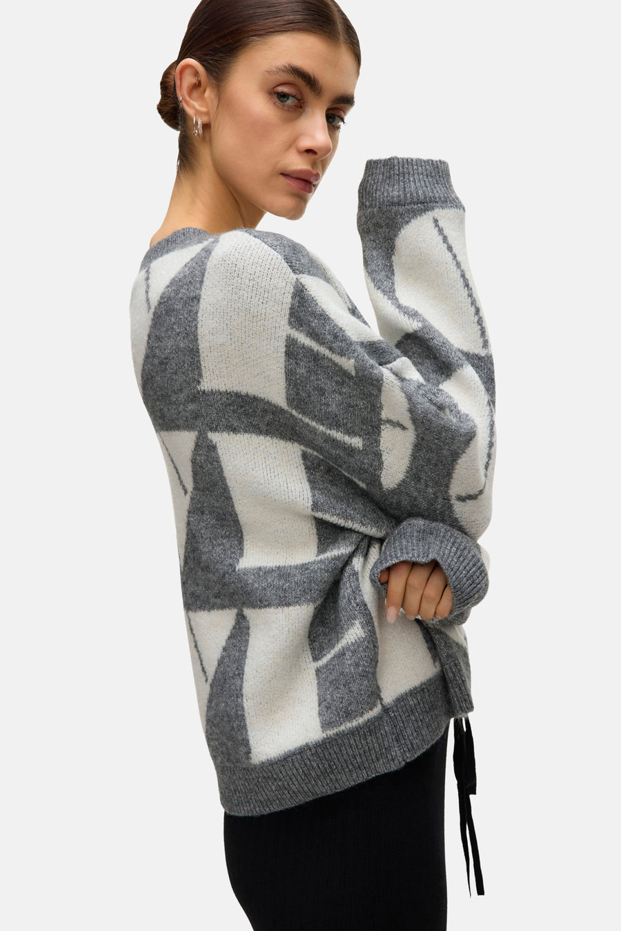 Grijze rondehals trui van VERO MODA® met geometrisch patroon en lange mouwen, gedragen met een zwarte broek.