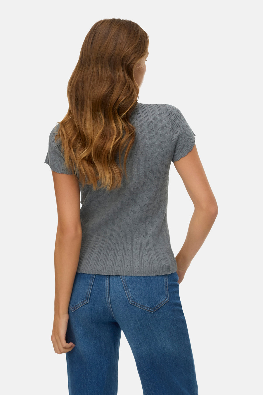 Grijs T-shirt met korte mouwen van Vero Moda, met een subtiel ajourpatroon, gedragen met een blauwe jeans.