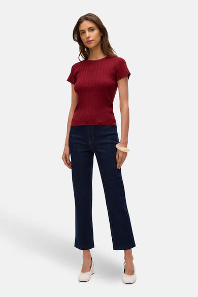 T-shirt rouge à manches courtes de VERO MODA, porté avec un jean taille haute et des ballerines blanches.
