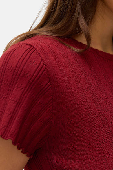 T-shirt rouge à manches courtes de VERO MODA® avec texture côtelée et détails ajourés.