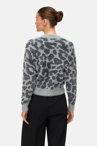 Grijze ronde nek pull van VERO MODA, vage leopardpatroon, gedragen met een zwarte broek.