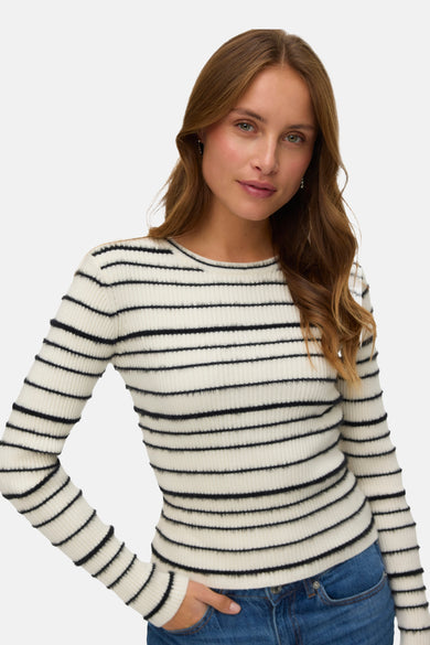 Pull à col rond blanc de VERO MODA avec motif à rayures horizontales, porté avec un jean bleu.