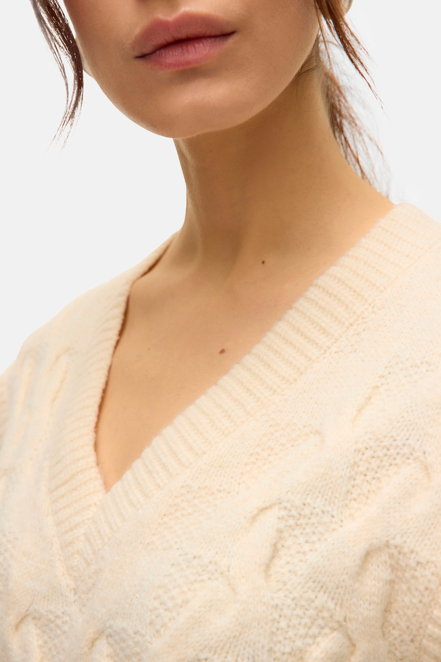 Débardeur beige de VERO MODA, en tricot torsadé à col en V sur une femme.