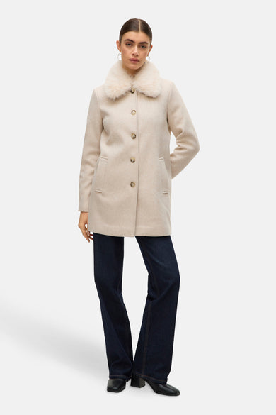 Ecru korte jas van VERO MODA met imitatiebontkraag, gedragen over een donkerblauwe flared jeans.