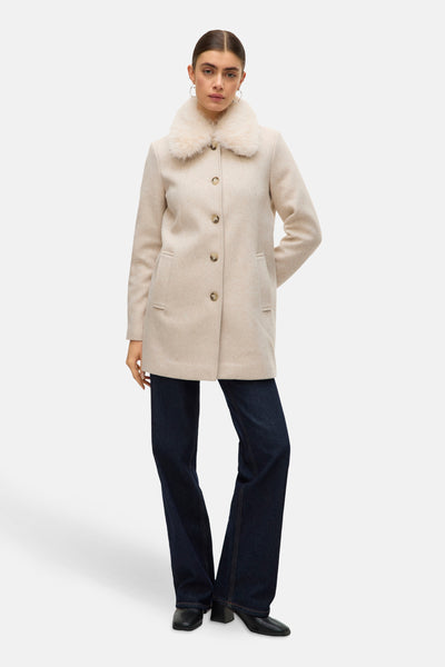 Ecru korte jas van VERO MODA met imitatiebontkraag, gedragen over een donkerblauwe flared jeans.
