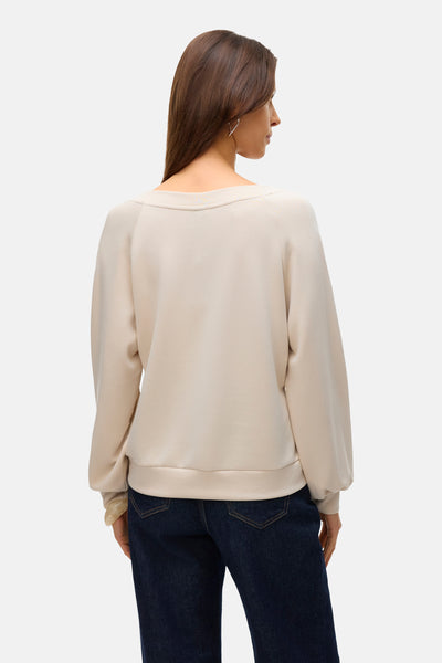 Beige trui van VERO MODA, gedragen met een donkerblauwe jeans, van achteren gezien, met lange pofmouwen.