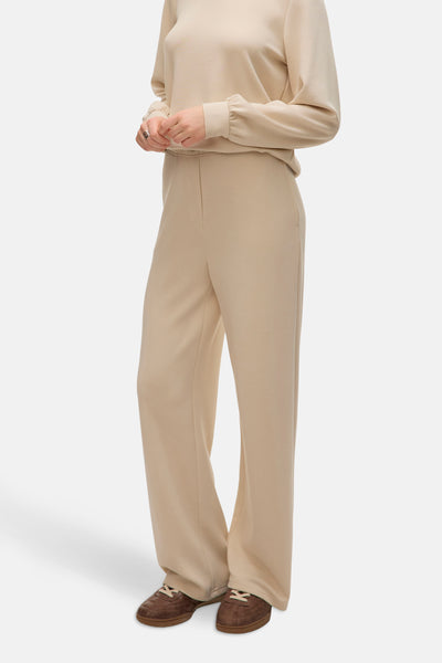 Pantalon écru de VERO MODA, jambe large et coupe droite, porté avec un pull beige et des chaussures marron.