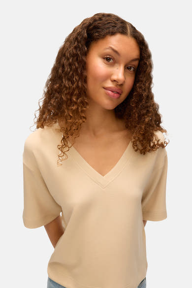 T-shirt écru à manches courtes de VERO MODA, avec un col en V.