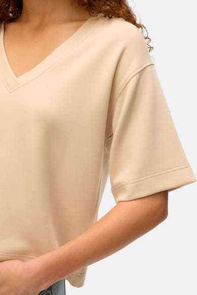 T-shirt écru à manches courtes de Vero Moda, avec encolure en V et ourlet simple.