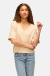 T-shirt écru à manches courtes de VERO MODA, porté avec un jean taille haute délavé.