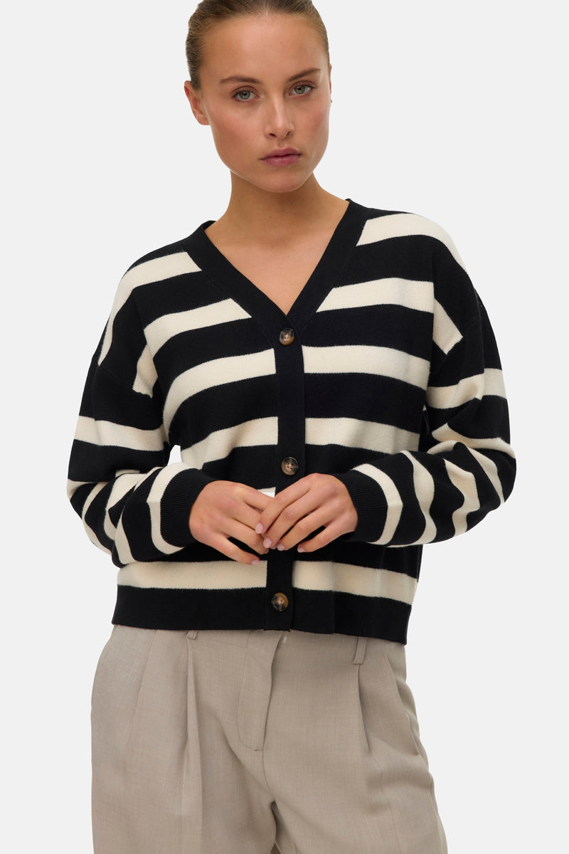 Multikleurige cardigan van VERO MODA®, zwart-witte horizontale strepen, gedragen met een beige broek.