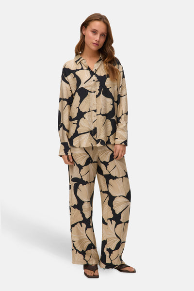 Multikleurige blouse met lange mouwen van VERO MODA® met zwart-beige bloemenpatroon, gedragen met een bijpassende broek.
